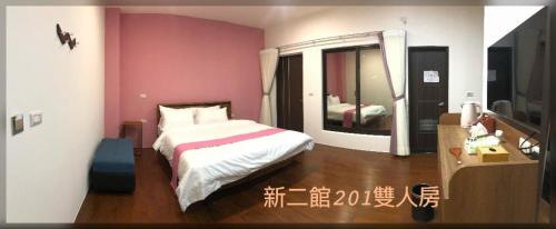 1 dormitorio con cama y espejo grande en 璟隆慢活仙境民宿二館 en Kung-t'ien-ts'un