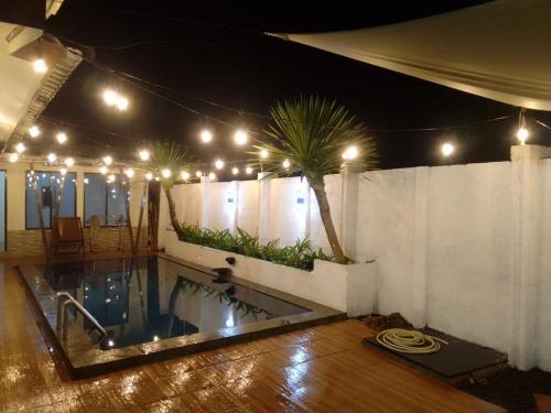 einen Pool mit Palmen und Lichtern in der Unterkunft Nyaman in Bogor