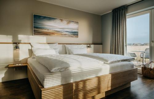 um quarto com uma cama grande e uma janela grande em Seaside 43 em Sankt Peter-Ording