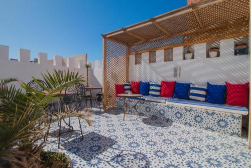 a patio with blue and red pillows on a building at Riad Dar Abi in Essaouira