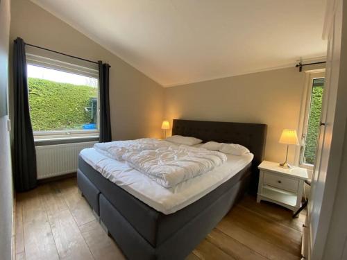 Un dormitorio con una cama grande y una ventana en Grevelingenlaan 30,Modern ingerichte Bungalow aan de Grevelingen,, en Scharendijke