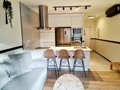 a kitchen with a counter and two stools in a room at Royal Park- Magical garden apartment in Eilat