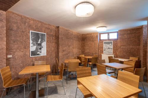 a dining room with wooden tables and chairs at San Luigi - Rooms & Apartments in Campodolcino