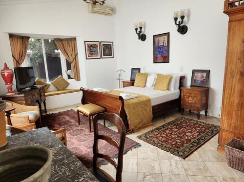 a bedroom with a bed and a desk and a television at Waterkloof Mansion Boutique Hotel in Pretoria