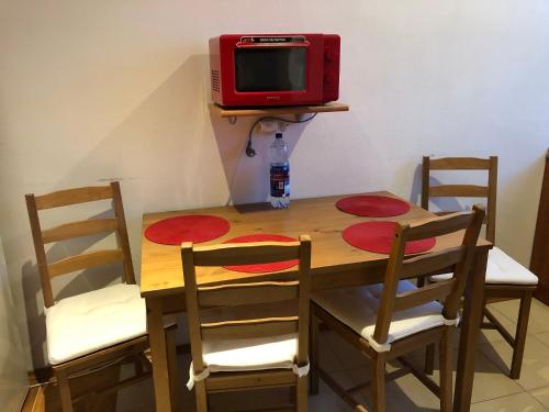 a wooden table with two chairs and a red tv at Apartmány Hágy L+L in Vysoké Tatry