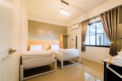 een slaapkamer met 2 bedden en een raam bij Royce Boutique Betong in Betong