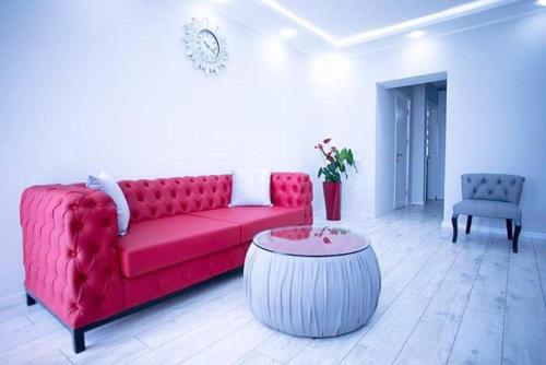 a living room with a red couch and a table at beautiful and comfortable apartment in the city center in an architectural building in Baku
