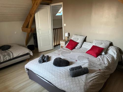 a bedroom with a large bed with red pillows at Gîte à la ferme: Coig de Lamothe in Aramits