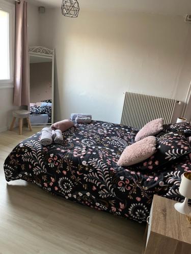 a bedroom with a bed with a black blanket and pillows at Gîte à la ferme: Coig de Lamothe in Aramits