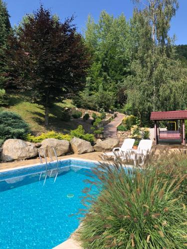 a swimming pool with two chairs and a bench at Veres in Yaremche