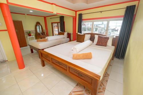 a bedroom with two beds and a large window at Jamesbond Bungalow Koh Panyee in Ko Panyi
