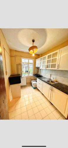 a kitchen with white cabinets and a tile floor at Private Room in Istanbul #85 in Arnavutköy