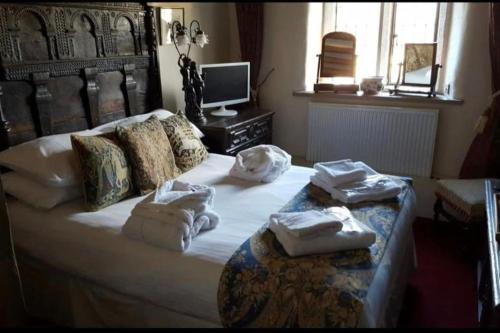 a bedroom with a bed with towels on it at Hagg Hill Hall in Wingerworth