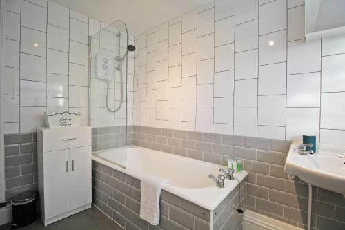 a bathroom with a bath tub and a sink at 2 bed, up to 6 guests near Chester City Centre in Chester