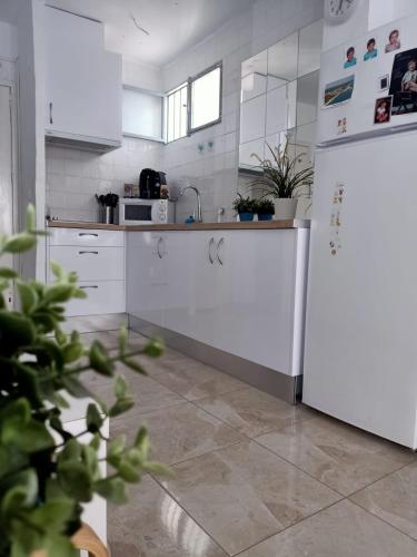 una cucina con armadietti bianchi e frigorifero bianco di Apartamento Rompeolas a Mazagón