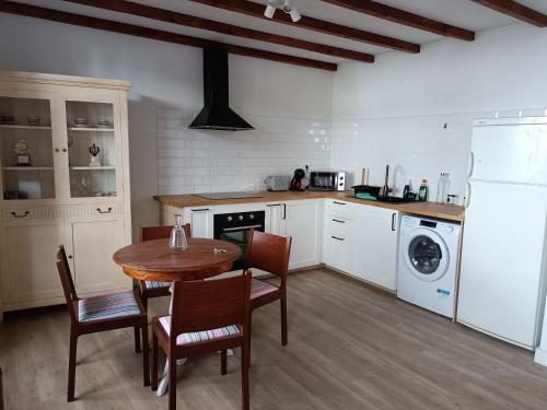 uma cozinha com mesa e cadeiras e uma máquina de lavar e secar roupa em Casa Las Enanitas II (Casa Elias) em Fuencaliente de la Palma