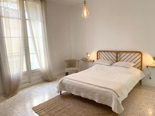 - une chambre blanche avec un lit et une fenêtre dans l'établissement Le Chai des Tuileries, à Montagnac