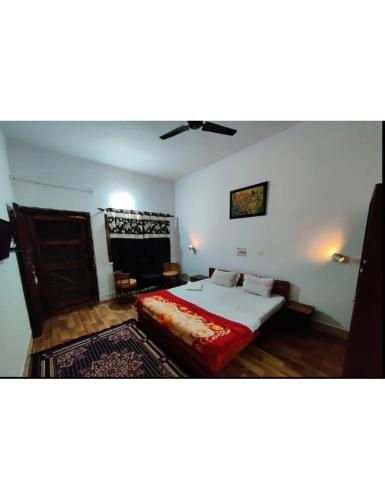 a bedroom with a bed and a couch in a room at Tigers Villa, Tala Bandhavgarh in Tāla