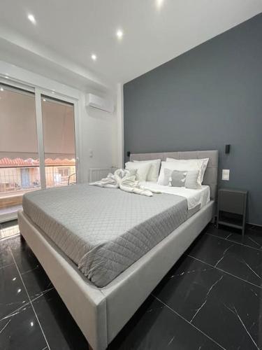 Cette chambre comprend un grand lit blanc et une fenêtre. dans l'établissement ATH-Brand new 2bedroom apartment, à Athènes