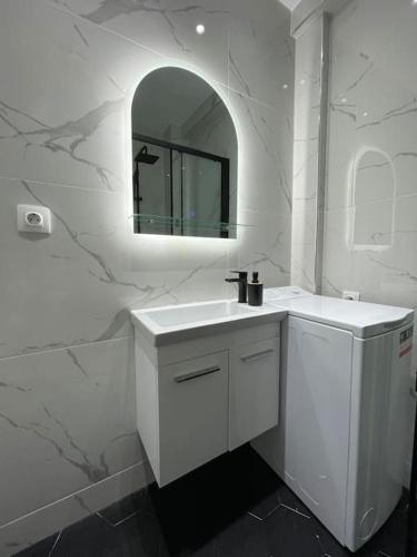 La salle de bains blanche est pourvue d'un lavabo et d'un miroir. dans l'établissement ATH-Brand new 2bedroom apartment, à Athènes