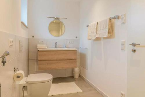 a white bathroom with a toilet and a sink at Appartment Amber in Überlingen