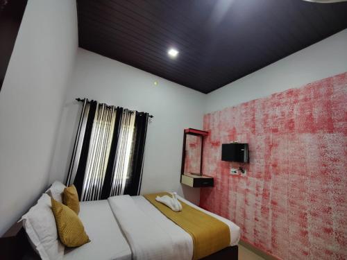 a bedroom with a bed and a red brick wall at Mazhavil homestay in Anachal