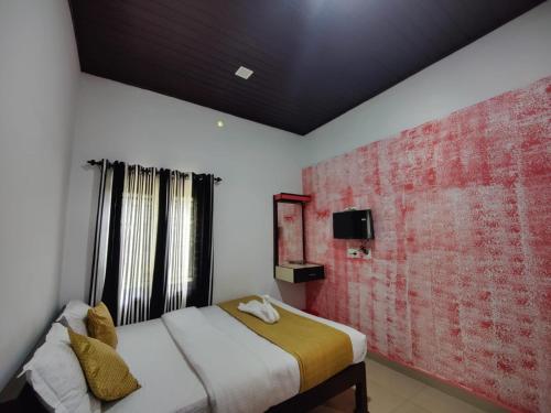 a bedroom with a bed and a red brick wall at Mazhavil homestay in Anachal