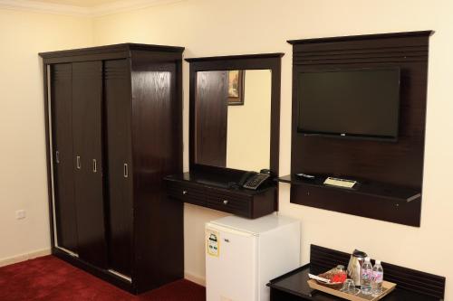 a room with two wooden cabinets and a television at Royal Almashaer in Makkah