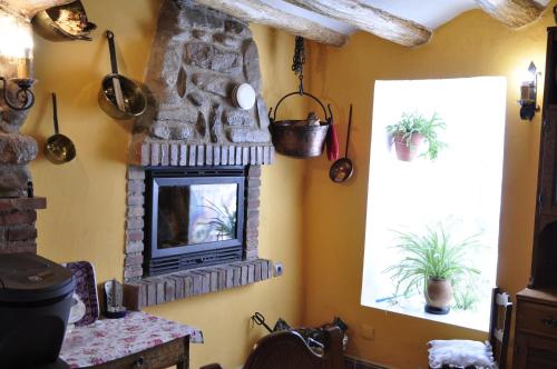 a living room with a stone fireplace and two windows at Casa Pradillo 