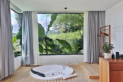 a bathroom with a bath tub in front of a large window at Purespace in Zhangjiajie