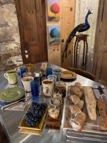 uma mesa com pão e outros alimentos em L'arbre à chapeaux em La GrandʼCombe-Châteleu