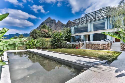 une maison avec une piscine et des montagnes en arrière-plan dans l'établissement Purespace, à Zhangjiajie