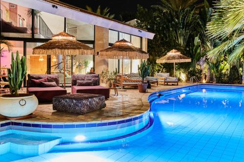 a swimming pool with chairs and umbrellas next to a building at Villa Balfour in Eilat