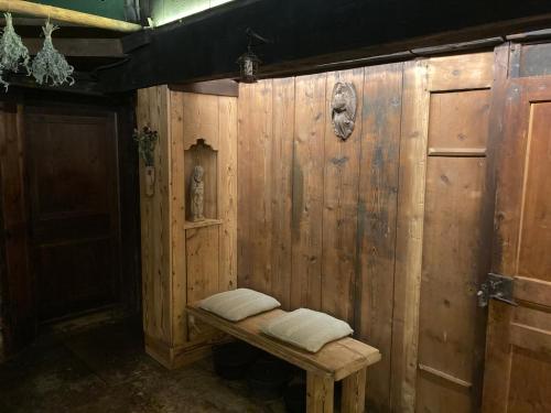 a wooden wall with two pillows on a bench at L'arbre à chapeaux in La GrandʼCombe-Châteleu