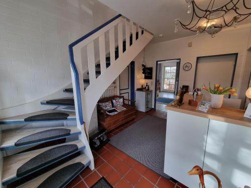 uma escada numa sala de estar com uma escada em Hotel Garni Friesenhuus em Greetsiel