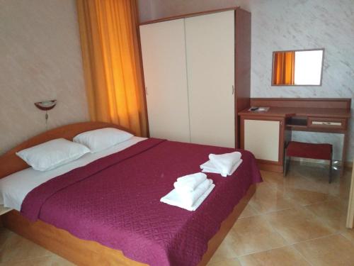 a bedroom with a bed with white towels on it at Apartments Dani in Pomorie