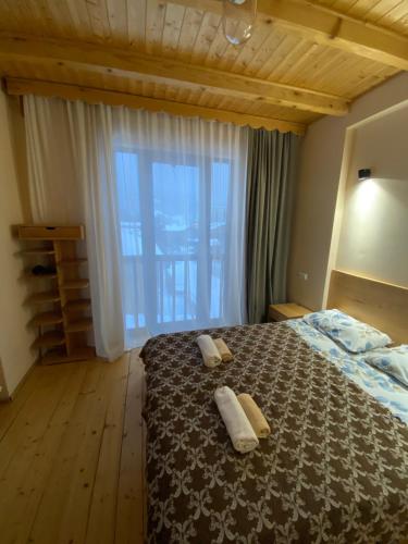 a bedroom with a bed with two towels on it at Sana Guest House in Mestia