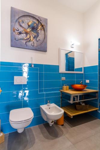a blue bathroom with a toilet and a sink at Casa Mazzini in Verona