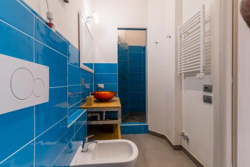 a bathroom with a sink and a blue tile wall at Casa Mazzini in Verona