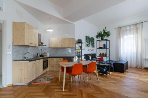 een keuken met een tafel en oranje stoelen. bij Casa Mazzini in Verona