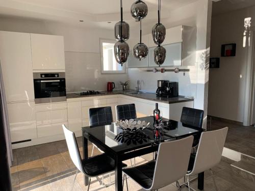 a kitchen with a black dining table and chairs at Apartment Dora in Makarska