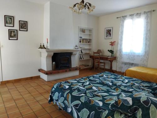 1 dormitorio con 1 cama y chimenea en Maison de campagne au cœur d'un élevage de poneys connemara, en Le Landreau