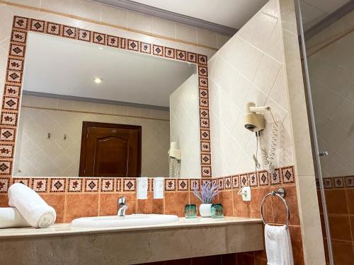 a bathroom with a sink and a large mirror at Beatriz Charming Hostal in Torremolinos