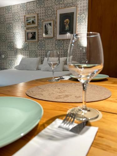 a wooden table with two wine glasses on it at Beatriz Charming Hostal in Torremolinos