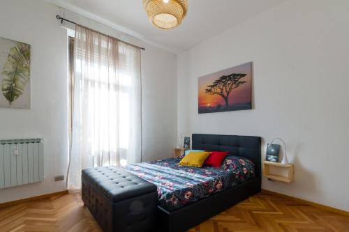 a bedroom with a bed with a couch and a window at Casa Mazzini in Verona