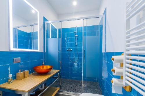 a bathroom with blue walls and a glass shower at Casa Mazzini in Verona