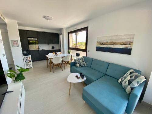 a living room with a blue couch and a table at New Apartment Las Lomas de Denia in Denia