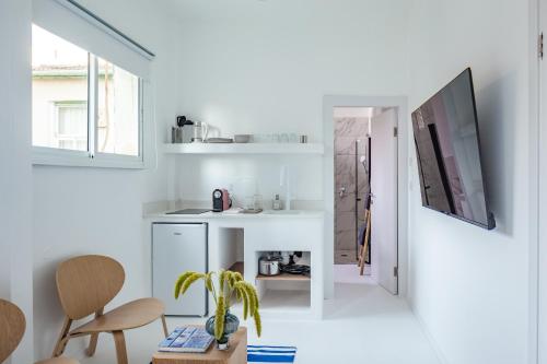 una cucina con pareti bianche, tavolo e sedie di Isla apartment's a Tel Aviv