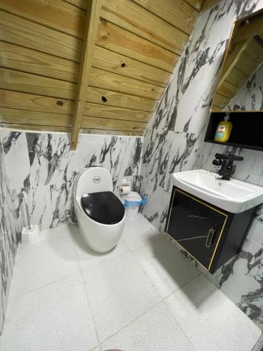 La salle de bains est pourvue de toilettes et d'un lavabo. dans l'établissement Villa completa confotable para 9 personas, à Pedernales