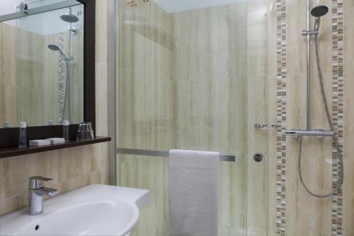 ein Bad mit einer Dusche, einem Waschbecken und einem WC in der Unterkunft The Originals City, Hôtel Paris Sud, Orly-Draveil in Draveil